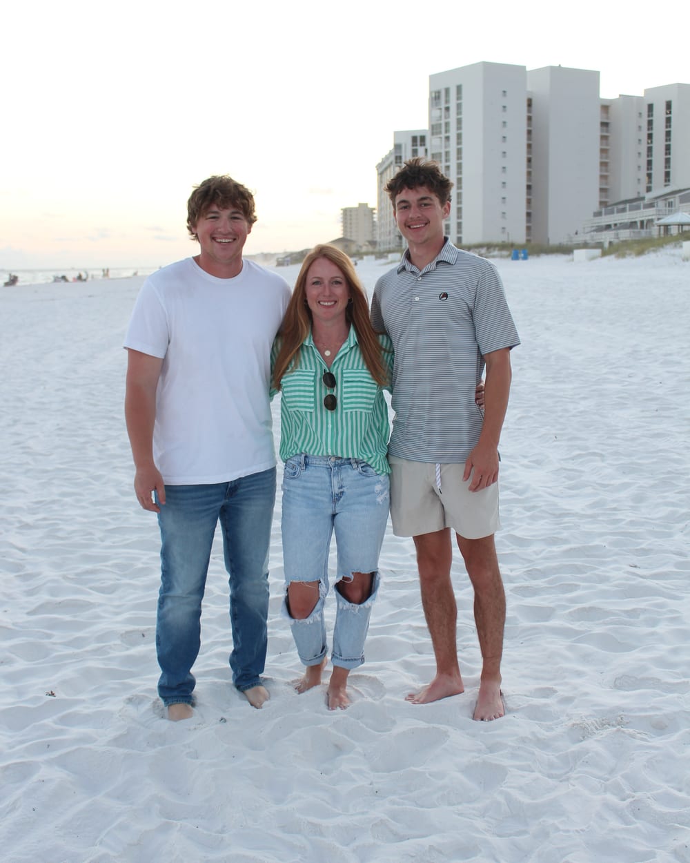 The two brothers who own Watson Exterior Cleaning, with their mom, on the beach at sunset